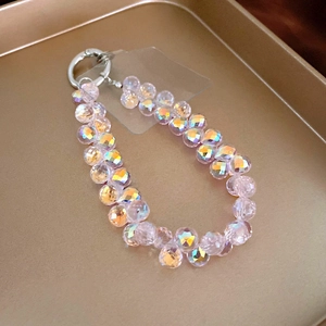 Detail of faceted rainbow pink crystal beads and silver round spring clasp on a tray