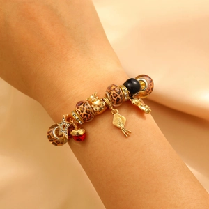 Golden charm bracelet with leopard beads, gold bear pendant and red heart on silk wrist