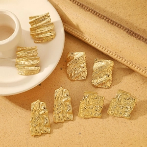 Detailed macro view of gold-tone irregular hammered texture geometric earrings set