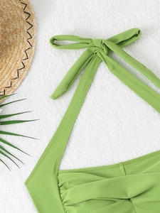 Detail view of green halter neck swimwear featuring ruched fabric and tie-neck design