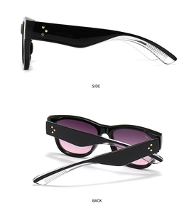 Detail of black cat-eye sunglasses with star rivets and purple gradient lenses