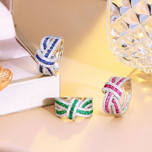 Detailed view of three adjustable crystal bow rings in blue, green and pink stones