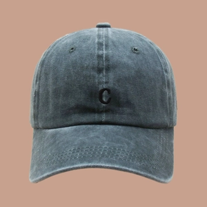 Close-up detail of the washed cotton fabric texture and embroidered letter C on baseball cap