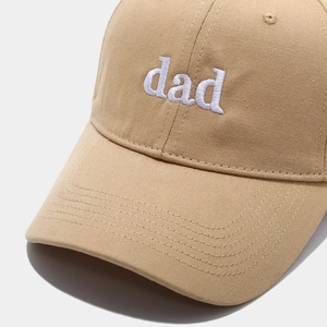 Close-up of white dad letter embroidery on khaki cotton twill baseball cap fabric