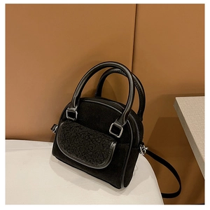 Detail of plush suede black shell handbag with smooth leather trim and handle