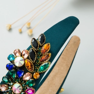 Close-up of Baroque headband with colorful crystals and deep green satin fabric