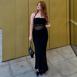 Détail d'une robe longue dos nu noire sexy avec patchwork en résille et découpe à la taille