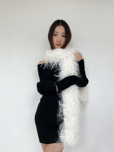 Detail showing high-quality white faux fur scarf texture on a black knit dress