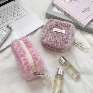 Detalle de bolsas de peluche con estampado de leopardo rosa y morado con cremallera y cinta