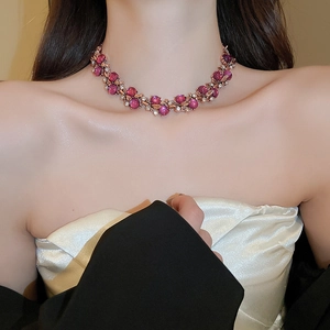 Close-up of vintage flower necklace with pink-purple beads and sparkling crystals on model