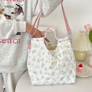 Détail du sac fourre-tout matelassé avec motifs lapins et fleurs et bandoulière rose