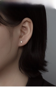 Gros plan d'un clou d'oreille carré minimaliste en argent S925 sur un mannequin