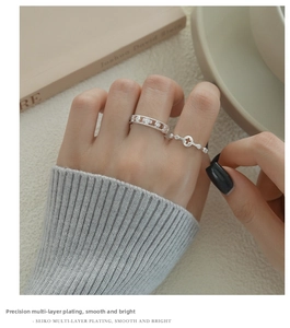 Close-up of stacked silver cross rings with cubic zirconia worn by a model