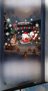 Detail of Christmas window stickers with Santa on a sleigh, reindeer, and snowflakes