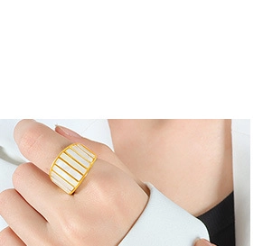 Detailed close-up of a gold ring featuring parallel white rectangular shell inlays