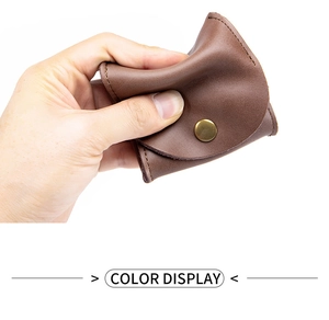 Detail of soft brown cowhide leather coin purse being squeezed to show material flexibility