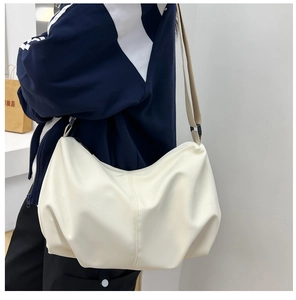Detail shot of pleated cream white shoulder bag featuring soft PU leather texture