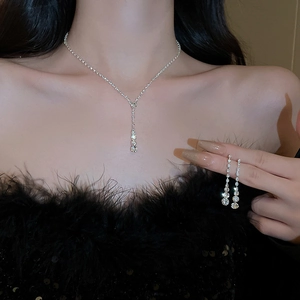 Ensemble élégant collier en Y argenté et boucles d'oreilles strass sur un mannequin