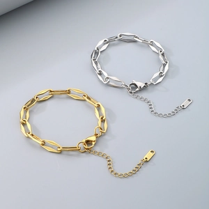 Macro detail of gold and silver Cuban chain links with K18 engraved tag and lobster clasp