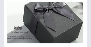 Macro shot of black textured jewelry box with a gray satin ribbon and elegant bow