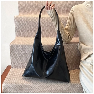 Close-up of the smooth black leather texture and minimalist design of the large tote bag
