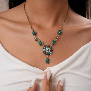 Detailed close-up of retro floral necklace with colorful crystals on a female model