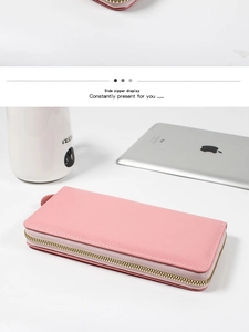 Detail view of pink long wallet with litchi grain texture and gold metal side zipper