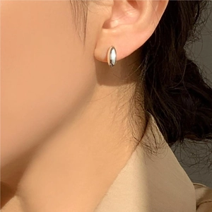 Close-up of a minimalist teardrop-shaped 925 sterling silver earring on a model ear