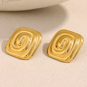 Vue macro des boucles d'oreilles labyrinthe carrées plaquées or 18 carats avec texture spirale