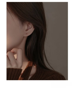 Close-up of minimalist S999 sterling silver four-pointed star stud earring on a model