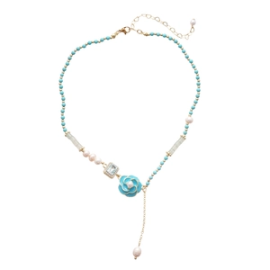 Blue beaded flower necklace with pearls and rectangular sapphire pendant on white background