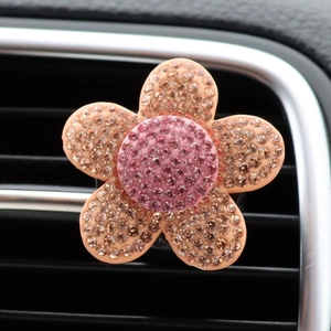 Close-up of a peach flower car air vent clip with sparkling champagne rhinestones