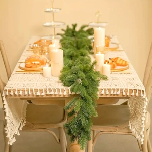 Close-up of 180cm artificial pine garland on lace runner with cozy holiday dining decor