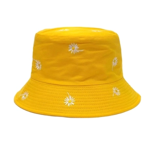 Detailed view of white daisy embroidery on the vibrant yellow cotton fisherman hat