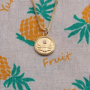 Détail d'un pendentif scarabée plaqué or avec zircon brillant sur une chaîne box