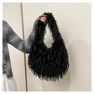 Detail of black faux fur handbag featuring soft fringe texture and fluffy plush material