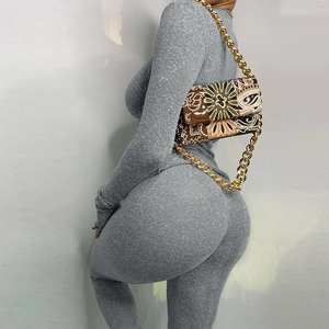 Detailed back view of a gray long-sleeve knit set with an ethnic print gold chain bag