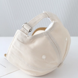 Détails de la boucle métallique réglable et des coutures de la casquette bébé beige