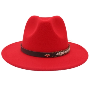 Detail of red wool fedora featuring a brown leather ethnic braided band and metal badge