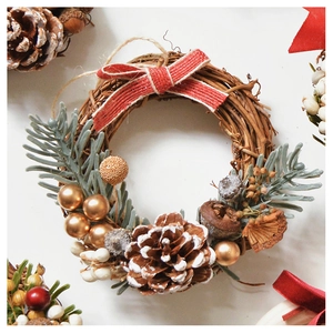 Detailed Christmas wreath featuring natural pine cones, red ribbons, and golden bells