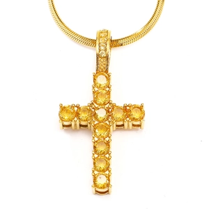 Detail of gold titanium cross pendant with sparkling yellow zircon stones and snake chain