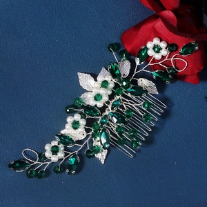 Detail of silver wire hair comb with green gemstones and white pearls for bridal styling