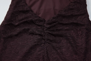 Détail du tissu en dentelle bordeaux avec design plissé sur cette robe d'été sexy