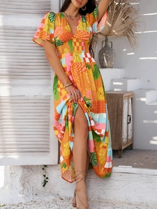 Detail of bohemian V-neck dress with tropical print and high waist ruffled short sleeves