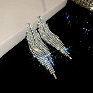 Gros plan de boucles d'oreilles trapèze argentées avec pampilles de strass brillants
