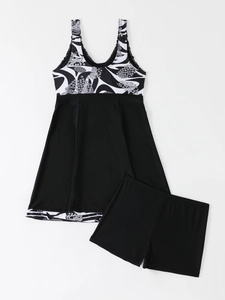 Flat lay of a black tankini set with printed skirt top and solid black boyshorts
