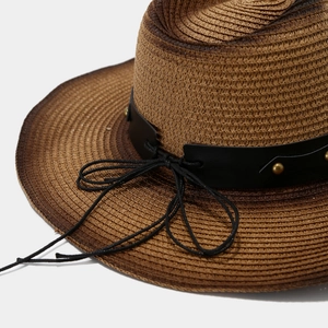 Detail of dark brown woven cowboy hat with black leather band and gold stud accents