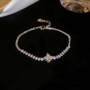 Macro shot of clover bracelet featuring pear-cut cubic zirconia on black velvet background