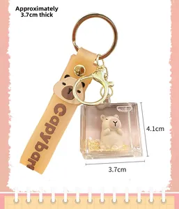 Detail view of liquid quicksand key chain with capybara figurine and orange strap
