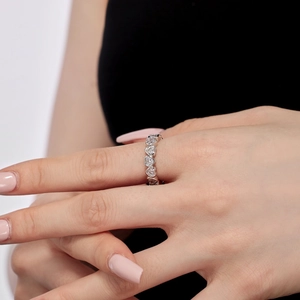 Close-up of S925 sterling silver heart-cut cubic zirconia eternity band on finger